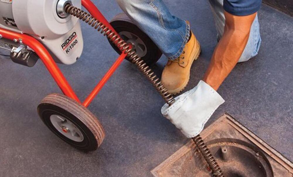 RIDGID sectional drain cleaning machine clearing a blocked drain