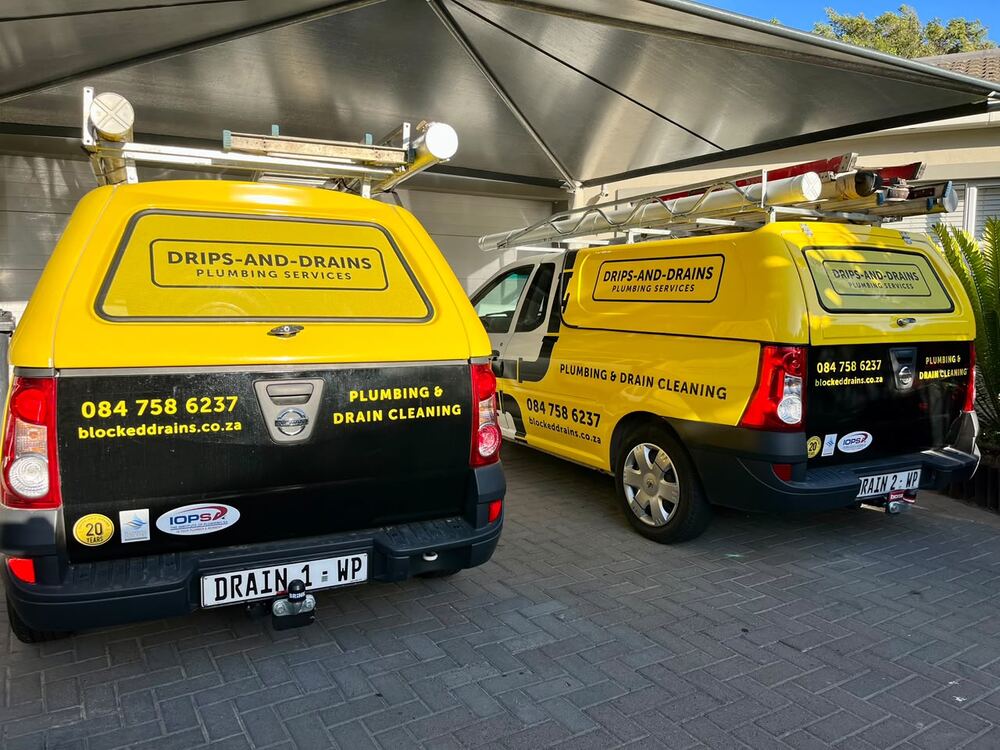 Two branded Drips-and-Drains plumbing and drain cleaning vehicles